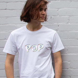 I'm With The Band® Bubble Pop T-shirt with iridescent white print on white T being worn by a cool young man standing against a white painted brick wall