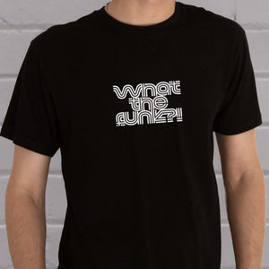 I'm With The Band® What The Funk?!" T-shirt with white print on black T-shirt  close up against a painted brick wall